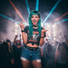 A woman with green hair performing energetically on stage at a concert, with colorful lights and a crowd in the background.